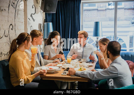 Les amis appréciant leur petit-déjeuner ensemble Banque D'Images