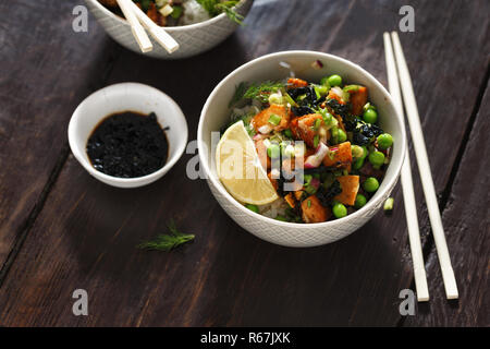 Bol avec le tofu, le riz, les algues, les pois verts et oignons sur table en bois. Savoureux et sain de la nourriture végétarienne. Bol poke végétarien Banque D'Images