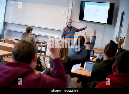 28 novembre 2018, Berlin, Neustrelitz : Hans-Herbert Gmbh, enseignant au gymnase Carolinum à Neustrelitz, donne des leçons de mathématiques sur un écran. Ses étudiants travaillent avec des IPAD en classe. Photo : Britta Pedersen/dpa-Zentralbild/ZB Banque D'Images