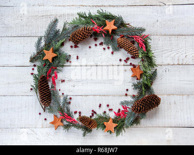 Couronne de Noël en télévision style laïcs fabriqués à partir de pommes de pin, des noix de coco stars et les fruits rouges. L'espace pour votre produit ou le texte Banque D'Images