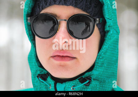 Portrait d'un athlète cycliste féminine en lunettes de soleil dans la forêt d'hiver. Le cycliste de vélo de cyclocross dans la forêt enneigée en hiver. Worko Hiver Banque D'Images