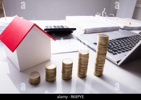 Pile de pièces en face de la maison modèle et Documents Banque D'Images