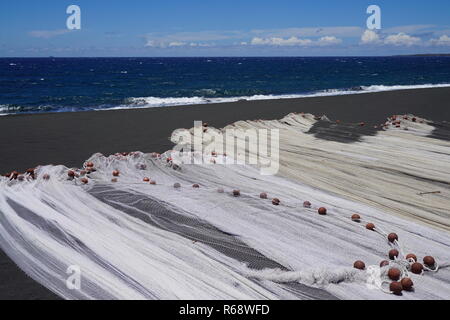 Plusieurs filets de pêche mises à sécher sur une plage de sable noir de la Réunion, France Banque D'Images