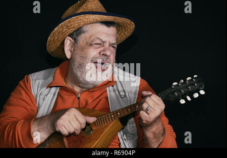 Touche bas Nice portrait of senior musicien avec mandoline jouer et chanter la musique country Banque D'Images