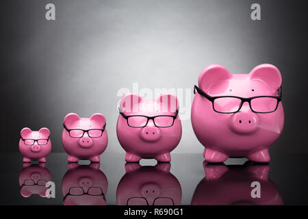 Porter des lunettes roses Piggybanks Banque D'Images