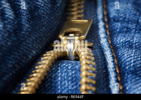 Fermeture éclair en laiton décompressé closeup on blue jeans Banque D'Images