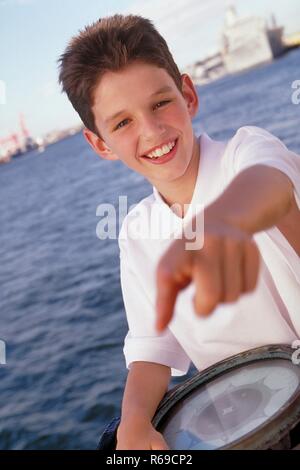 Hafen, Portrait, 14-jaehriger bekleidet Junge mit weissem Hemd An Bord eines Boots mit einem Kompass in der Hand Banque D'Images