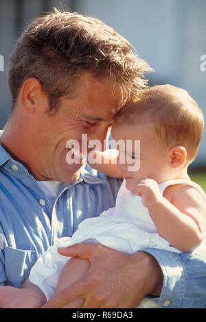 Piscine, Portrait, stolzer Vater im Jeanshemd mit seinem Baby auf dem Arm Banque D'Images