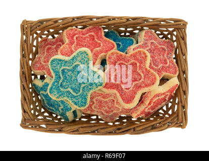 Vue de dessus d'un petit panier rempli de sucre en forme d'étoile bleu et rouge avec des cookies nutrifer isolé sur un fond blanc. Banque D'Images