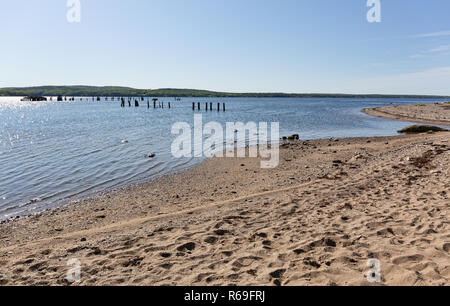 Voir Sandy Point Beach Park à Stockton Springs, dans le Maine par un beau matin ensoleillé avec les restes d'une jetée au loin. Banque D'Images