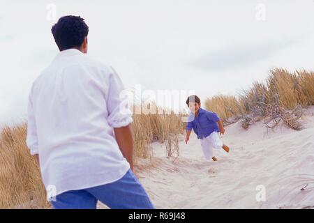 Strandszene, Ganzfigur, Mann, Mitte 30, mit weissem Hemd Jeans und mit seinem 4 tobt ausgelassen jaehrigem-Sohn dans 'The Fashion den Duenen Banque D'Images