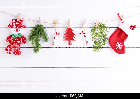 Noël arrière-plan concept. Vue du dessus de l'arbre de Noël avec des chaussettes et des fruits rouges, des branches d'épinette et bonhomme de s'accrocher sur la corde blanche en bois backgrou Banque D'Images