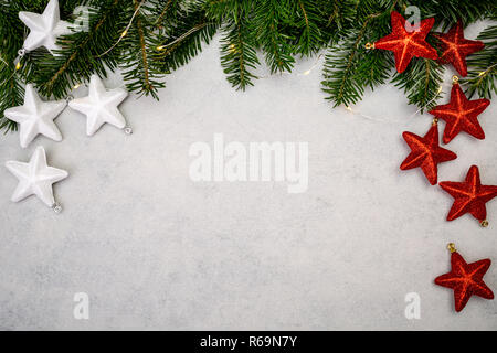 Fond de Noël avec sapin, blanc et rouge brillant étoile sur table béton gris. Vue de dessus avec l'exemplaire de l'espace. Banque D'Images