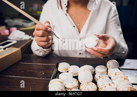 Processus permettant de macarons. L'accent peu profondes avec pinceau peinture alimentaire. Banque D'Images