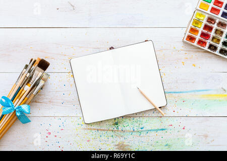 Contexte artistique créative de l'espace de conception, de mise à plat de l'ordinateur portable des maquettes de l'art avec des peintures à l'aquarelle, crayon et pinceaux set on white woo Banque D'Images