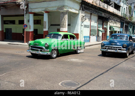 Deux vintage des années 50 nous les voitures qui circulent dans les rues en ruines de La Havane Cuba Banque D'Images