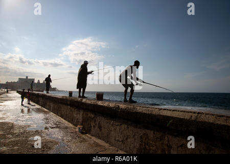 Des silhouettes d'hommes cubains pour pêcher sur le Malecon à La Havane Cuba Banque D'Images