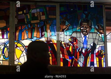 Un deuil est vu en face d'un vitrail représentant Nelson Mandela lors d'un service religieux pour l'ancien Président sud-africain à Regina Mundi, Soweto, le dimanche 8 décembre 2013. Le vétéran est décédé jeudi soir, le 5 décembre 2013. PHOTO : EVA-LOTTA JANSSON Banque D'Images