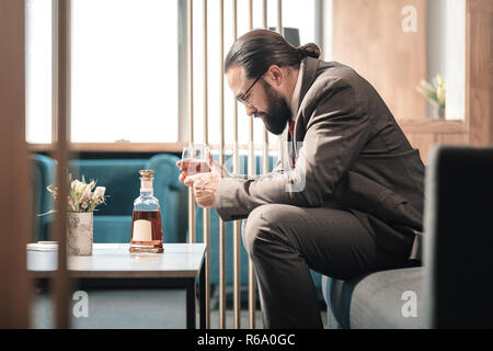 Dark-haired barbu sentiment horrible après des problèmes au travail Banque D'Images