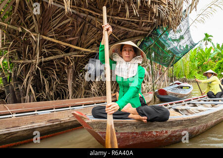 MY Tho, Vietnam - 24 NOVEMBRE 2018 : Les femmes vietnamiennes dans le bouchon traditionnel vietnamien pagayez dans un petit bateau avec des touristes sur le Mékong dans mon e Banque D'Images