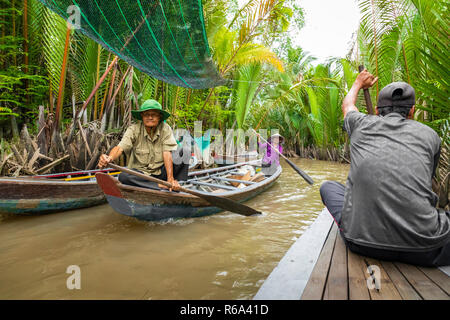 MY Tho, Vietnam - 24 NOVEMBRE 2018 : Delta du Mékong croisière dans la jungle avec artisan pêcheur non identifiés et des barques sur les inondations boueuses lotus fi Banque D'Images