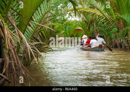 MY Tho, Vietnam - 24 NOVEMBRE 2018 : Delta du Mékong croisière dans la jungle avec artisan pêcheur non identifiés et des barques sur les inondations boueuses lotus fi Banque D'Images