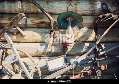 Vieux outils rustiques, accroché sur le mur en bois de la chambre. Banque D'Images