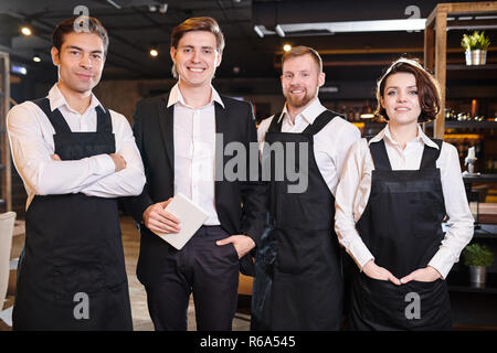 Le restaurant de l'équipe de professionnels à l'avant de la queue manager and smiling at camera Banque D'Images