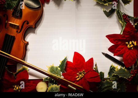 Violon et ouvrir le manuscrit sur le fond rouge. Concept de Noël Banque D'Images