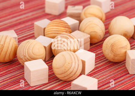 Les billes de bois et des cubes sur fond tissu rayé. Banque D'Images