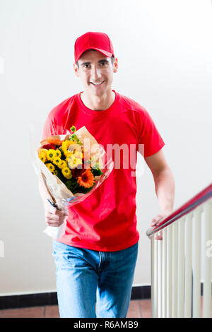 Delivery man avec de beaux cadeaux bouquet de fleurs Banque D'Images