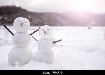 Deux petits bonhommes, peu dans la nature dans la neige, journée froide dans les montagnes. Concept de belle de l'hiver et les enfants s'amusant en famille ou en vacances. Joyeux Banque D'Images