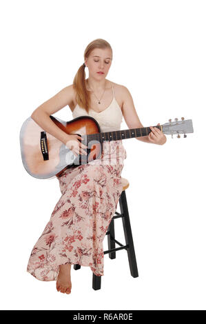 Femme assise avec sa guitare et chant Banque D'Images