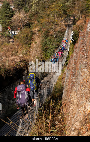 Le Népal, Thado Koshi Gaon, trekkeurs crossing Thado Koshi pont suspendu de Kola Banque D'Images