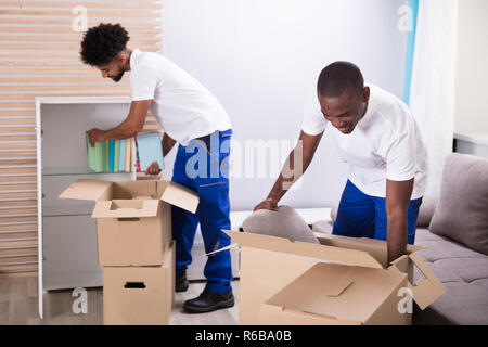 Movers déballage du carton à la maison Banque D'Images