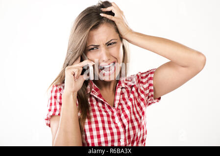 Belle jeune femme parlant au téléphone. Elle a des problème et a souligné tirant ses cheveux. Banque D'Images