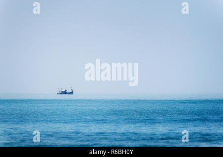Chalutier bleu solitaire dans l'océan en Inde Banque D'Images