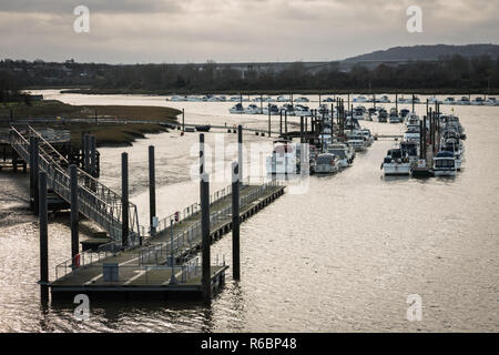 Vue d'une jetée et de la jetée menant à une flottille de bateaux amarrés sur la rivière Medway à Rochester, Angleterre, Royaume-Uni lors d'une froide journée d'hiver, avec l'exemplaire de l'espace. Banque D'Images