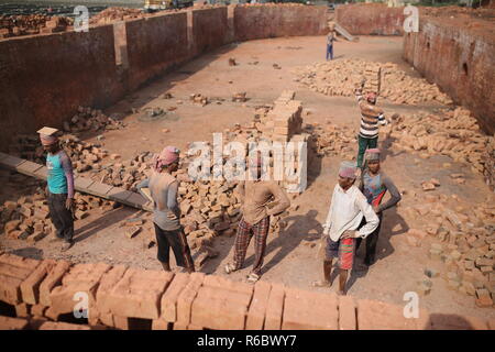 Labeurs sont vus dans un champ en brique à Dhaka, au Bangladesh. Travaux y compris les enfants travaillent sur le champs jusqu'à la tombée de la brique avec une mauvaise condition comme leur salaire pas de norme minimale. La croissance la plus rapide du Bangladesh a classé pays au monde que l'urbanisation progresse rapidement. En dépit de la brique est la clé pour construire la structure du bâtiment en tant que grand nombre de chantiers en briques de terres agricoles a eu lieu dans la réduction de la production agricole. La plupart des chantiers de bois, l'utilisation de la brique pour brûler du charbon comme la brique crue d'émission de gaz CO2. Banque D'Images