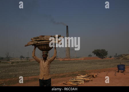 Un homme travaille dans un champ de brique avec des conditions insalubres à Dhaka, au Bangladesh. Travaux y compris les enfants travaillent sur le champs jusqu'à la tombée de la brique avec une mauvaise condition comme leur salaire pas de norme minimale. La croissance la plus rapide du Bangladesh a classé pays au monde que l'urbanisation progresse rapidement. En dépit de la brique est la clé pour construire la structure du bâtiment en tant que grand nombre de chantiers en briques de terres agricoles a eu lieu dans la réduction de la production agricole. La plupart des chantiers de bois, l'utilisation de la brique pour brûler du charbon comme la brique crue d'émission de gaz CO2. Banque D'Images