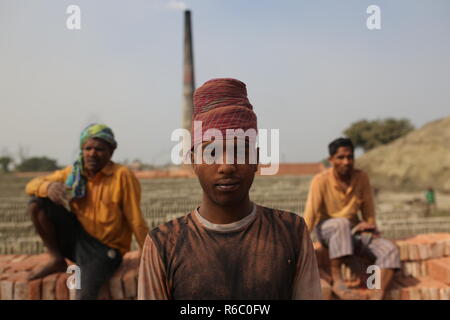 Labeurs sont vus dans un champ en brique à Dhaka, au Bangladesh. Travaux y compris les enfants travaillent sur le champs jusqu'à la tombée de la brique avec une mauvaise condition comme leur salaire pas de norme minimale. La croissance la plus rapide du Bangladesh a classé pays au monde que l'urbanisation progresse rapidement. En dépit de la brique est la clé pour construire la structure du bâtiment en tant que grand nombre de chantiers en briques de terres agricoles a eu lieu dans la réduction de la production agricole. La plupart des chantiers de bois, l'utilisation de la brique pour brûler du charbon comme la brique crue d'émission de gaz CO2. Banque D'Images