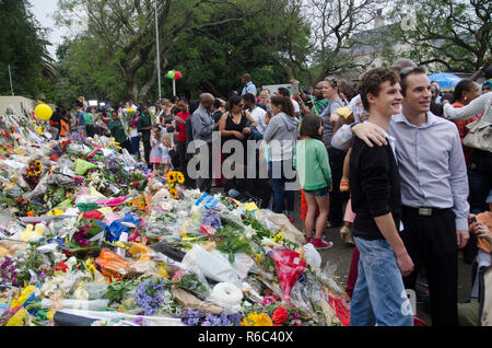 Deux hommes posent devant des tributs floraux à l'extérieur de l'ancien Président sud-africain Nelson Mandela's home à Houghton, Johannesburg, en Afrique du Sud, le 9 décembre 2013, que s'est rendu dans la région à la fin de semaine. Le vétéran est décédé Jeudi, Décembre 5, 2013. PHOTO : EVA-LOTTA JANSSON Banque D'Images