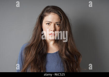 Jeune femme avec regard sérieux sur son visage Banque D'Images