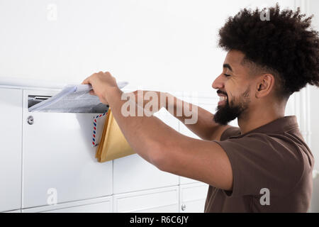 Mettre l'homme de lettres dans la boîte aux lettres Banque D'Images