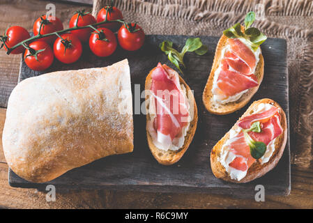 Sandwiches au fromage à la crème et au jambon sur la planche de bois Banque D'Images