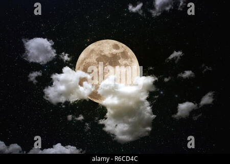 Composition Photo avec pleine lune dans la nuit, des nuages épais et un fond étoilé Banque D'Images