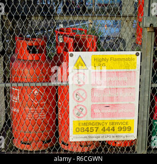 Les bouteilles de gaz en cage cadenassée avec panneaux d'avertissement Banque D'Images