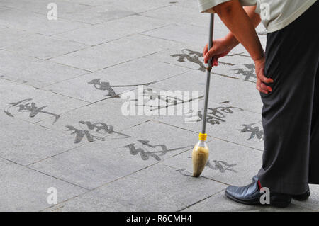La Chine, Beijing, l'homme écrit sur le terrain de calligraphie Banque D'Images