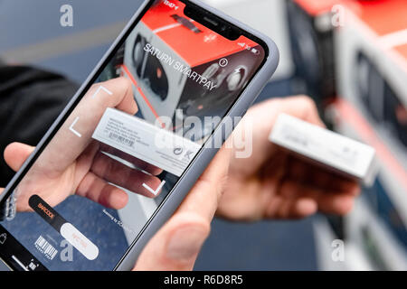 Hambourg, Allemagne. Le 05 mai 2018. Un utilisateur lit un produit : à partir du code-barres sur son téléphone mobile via une application. Avec 'Saturn Smartpay' Paiement Mobile, il peut maintenant payer directement en magasin via son téléphone mobile à l'aide d'une app. Photo : Markus Scholz/dpa/Alamy Live News Banque D'Images