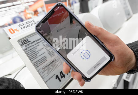 Hambourg, Allemagne. Le 05 mai 2018. Un utilisateur lit un produit prix d'une puce NFC dans l'étiquette des prix dans son téléphone mobile via une application. Avec 'Saturn Smartpay' Paiement Mobile, il peut maintenant payer directement en magasin via son téléphone mobile à l'aide d'une app. Photo : Markus Scholz/dpa/Alamy Live News Banque D'Images